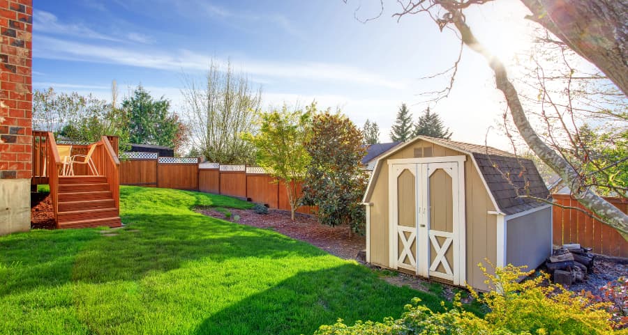 Fenced backyard with storage shed in Utica